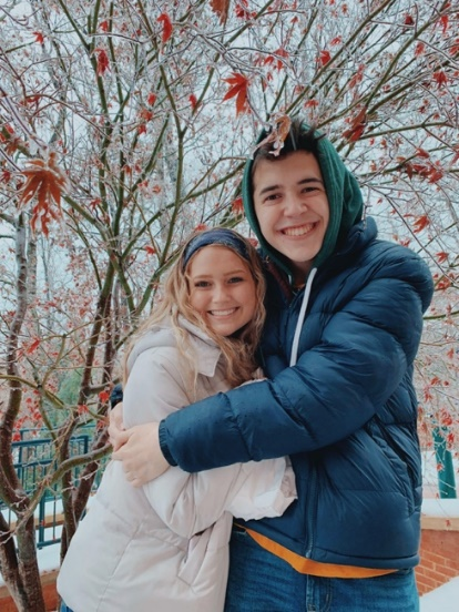 Two students hugging and smiling outside