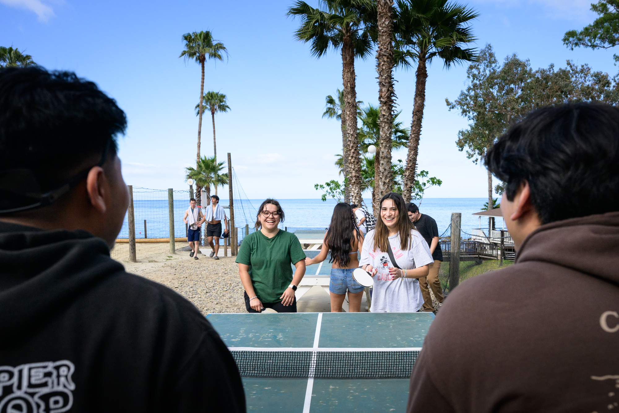 4 students try to play doubles Table Tennis.