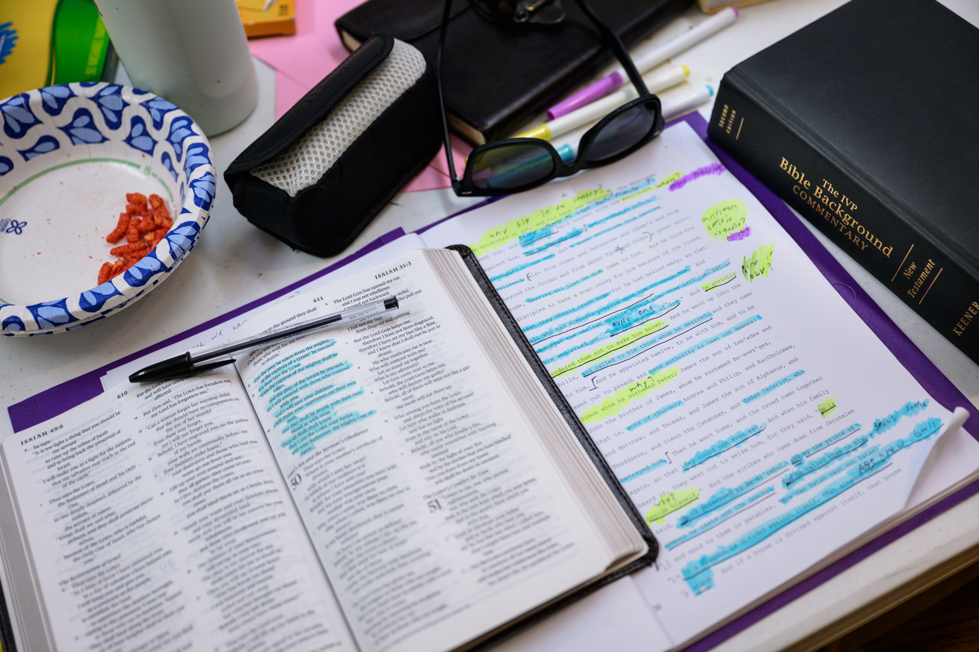 detailed photo of Bible and manuscript Bible passage highlighted and marked up