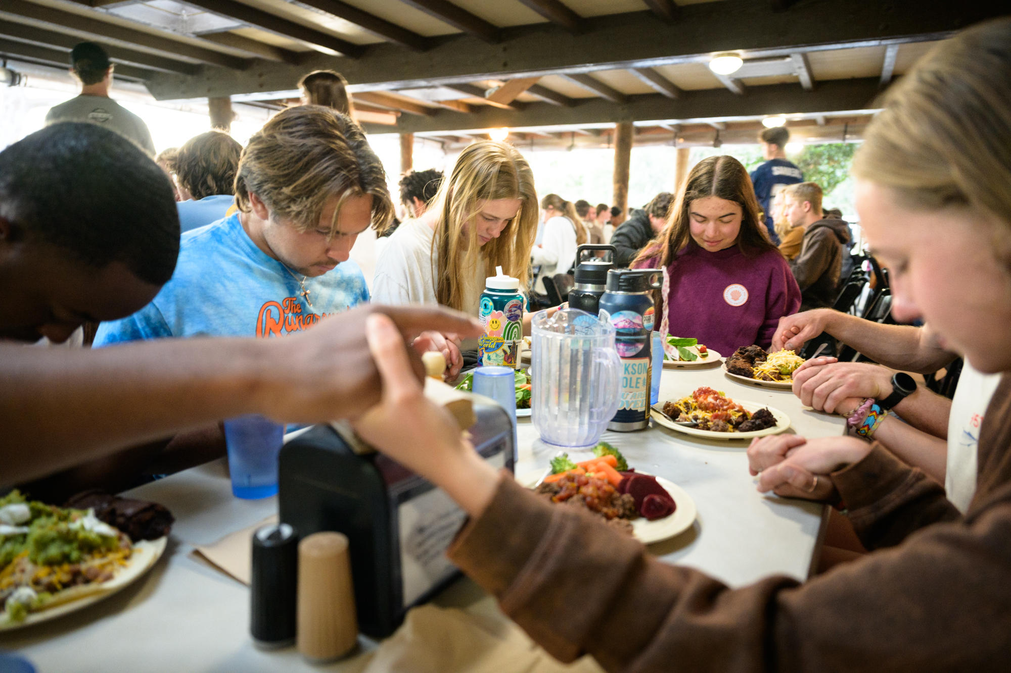 7 Student hold hands to pray before a meal.