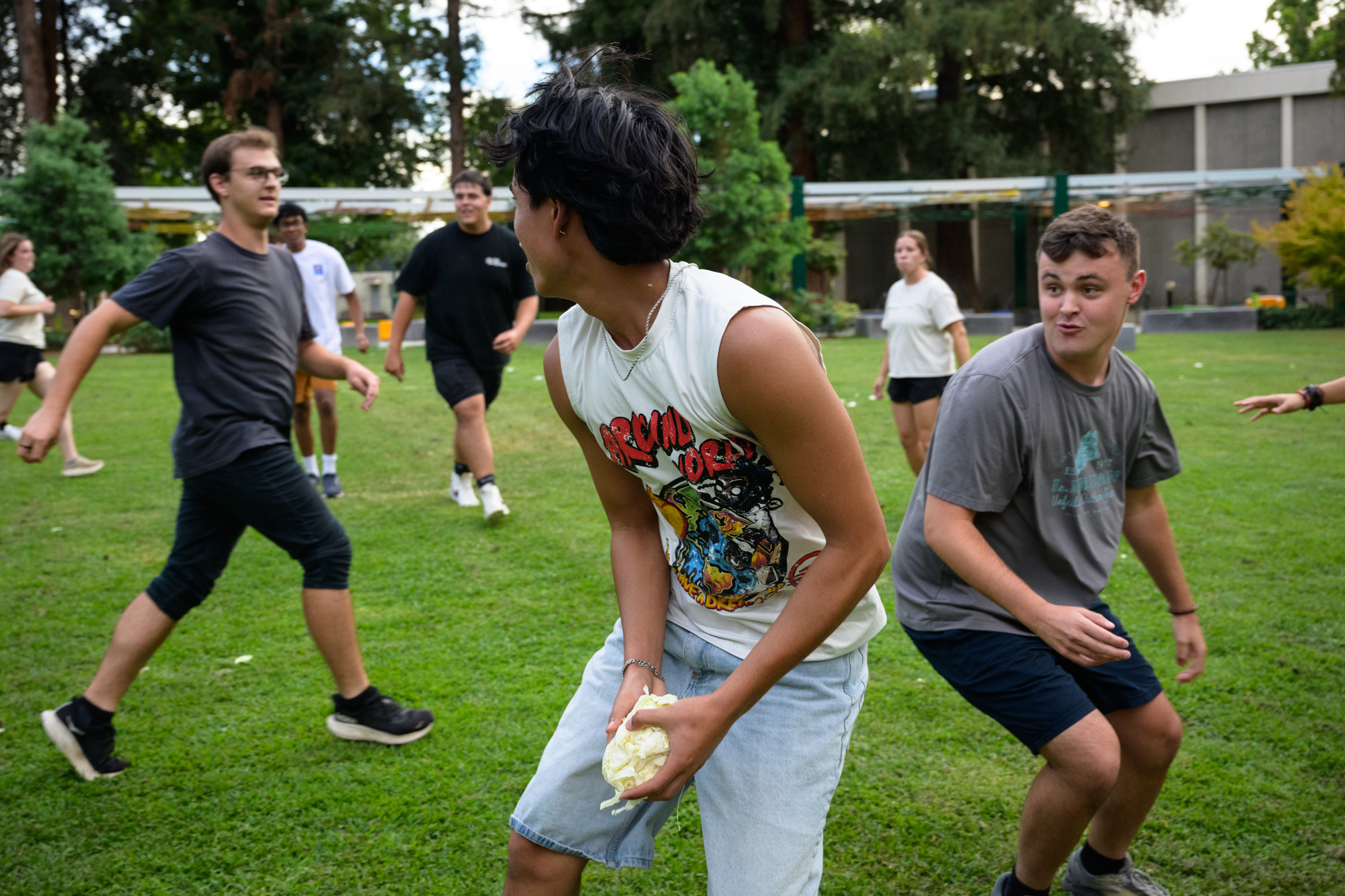 A student pivots away from a defender to toss a cabbage the other way.