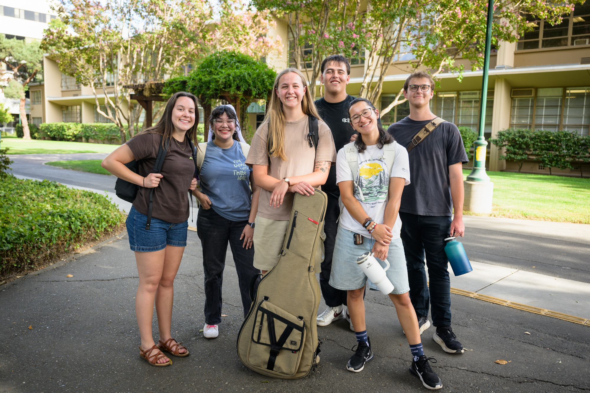 A group of students we recognize from other images stand smiling, looking at the camera.