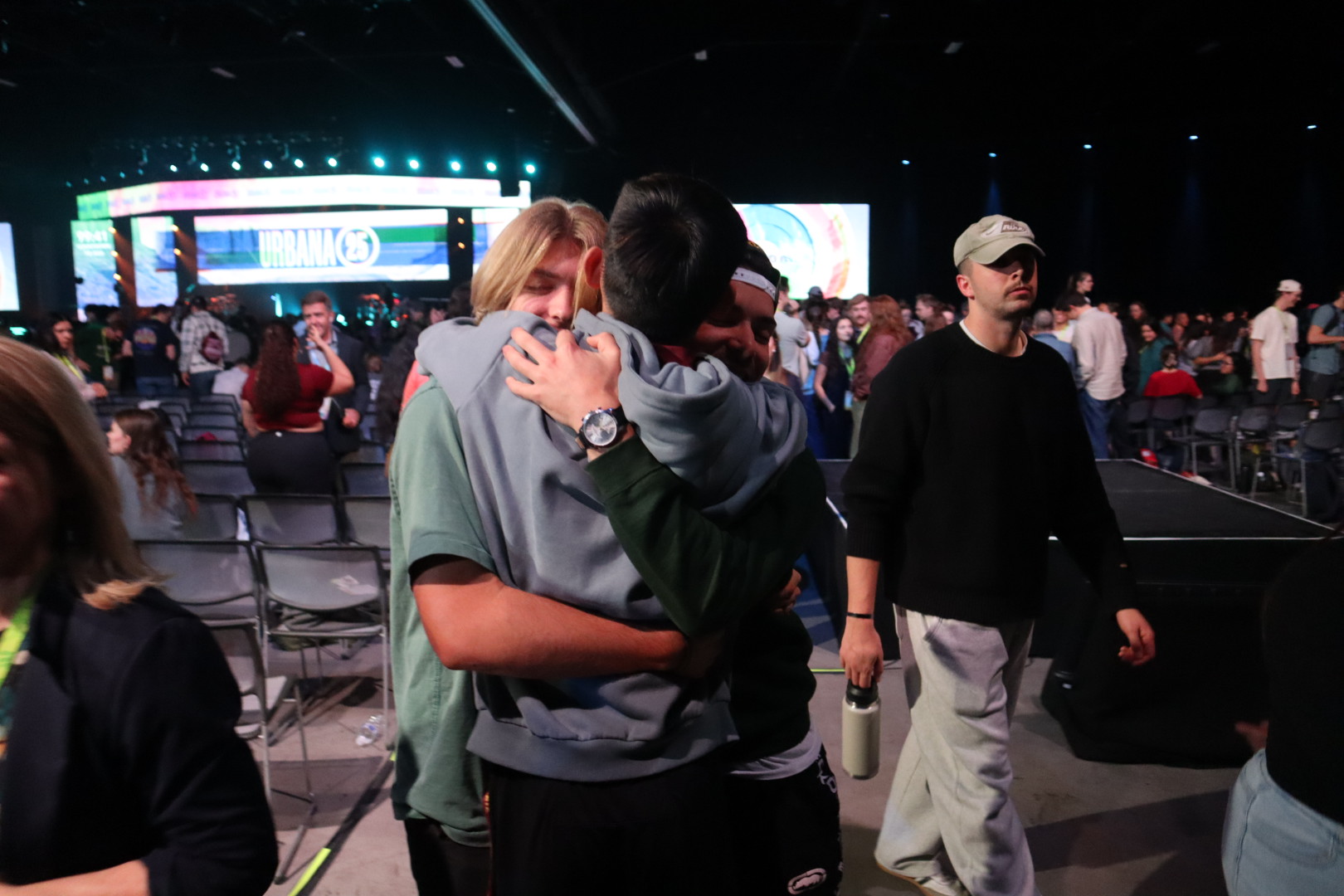 two students embrace in a hug at a conference