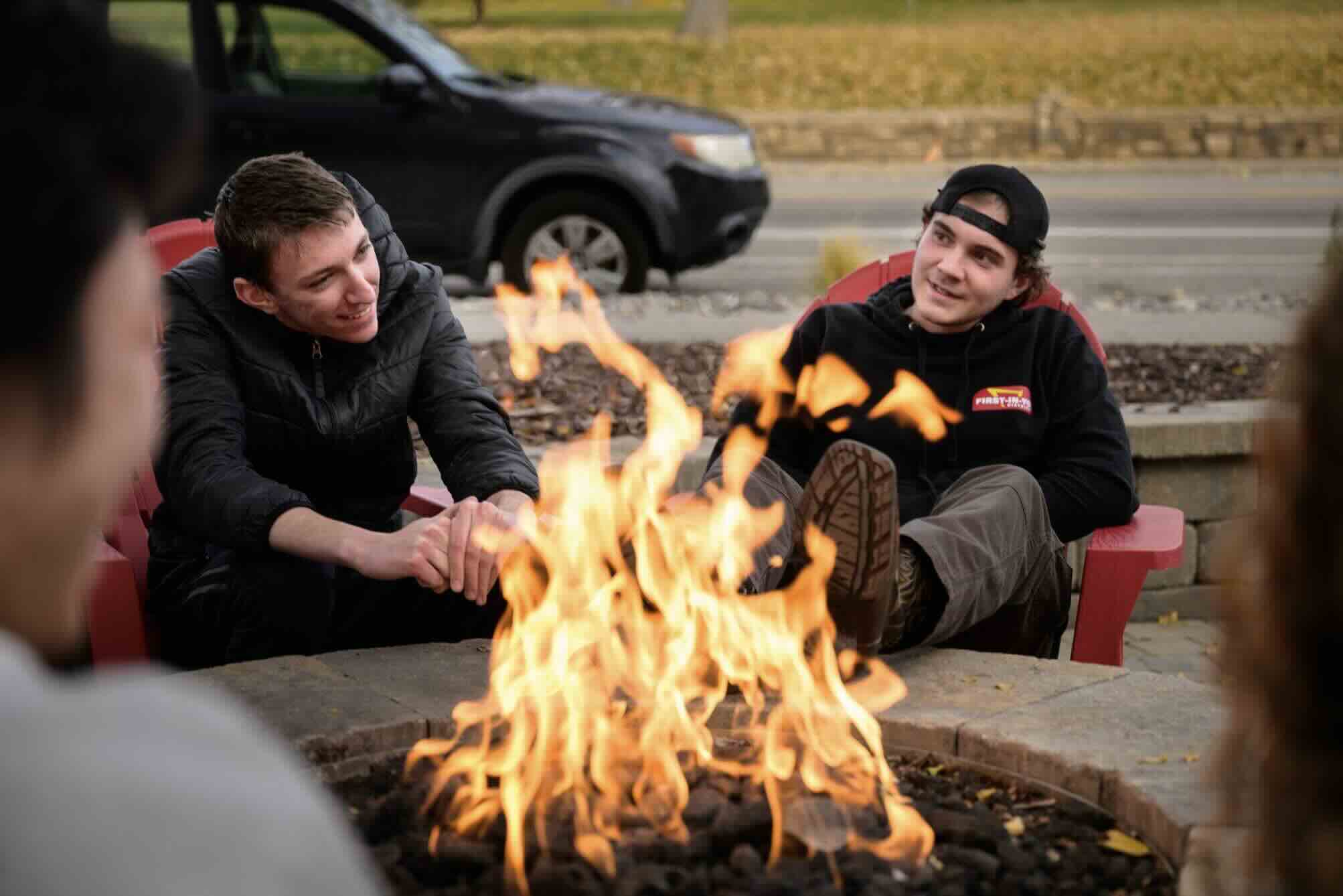 Sean sitting by fire with friends