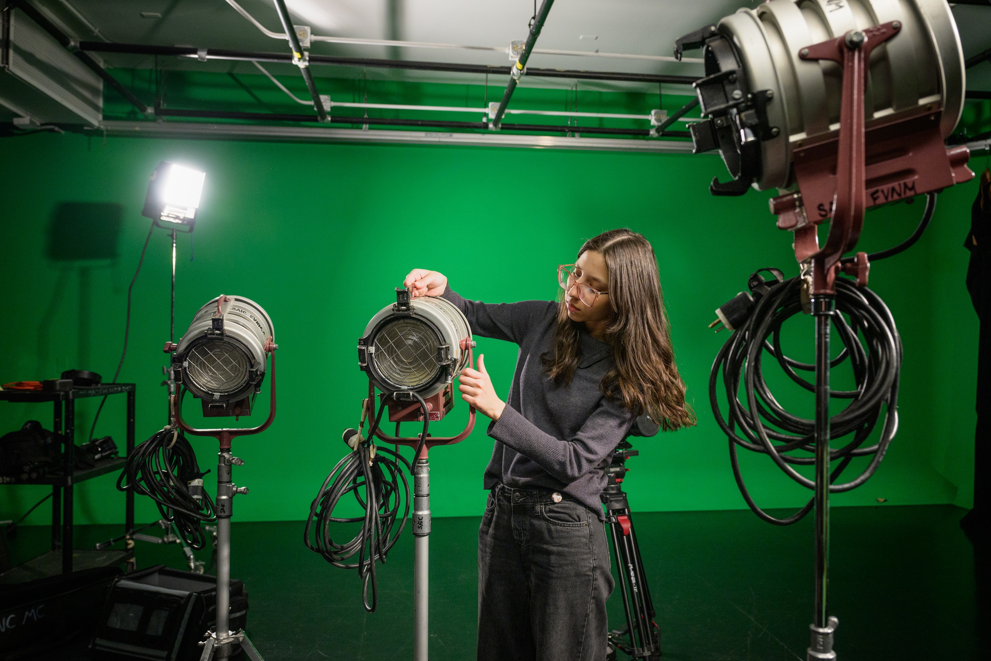 Ana sets up lighting in a studio