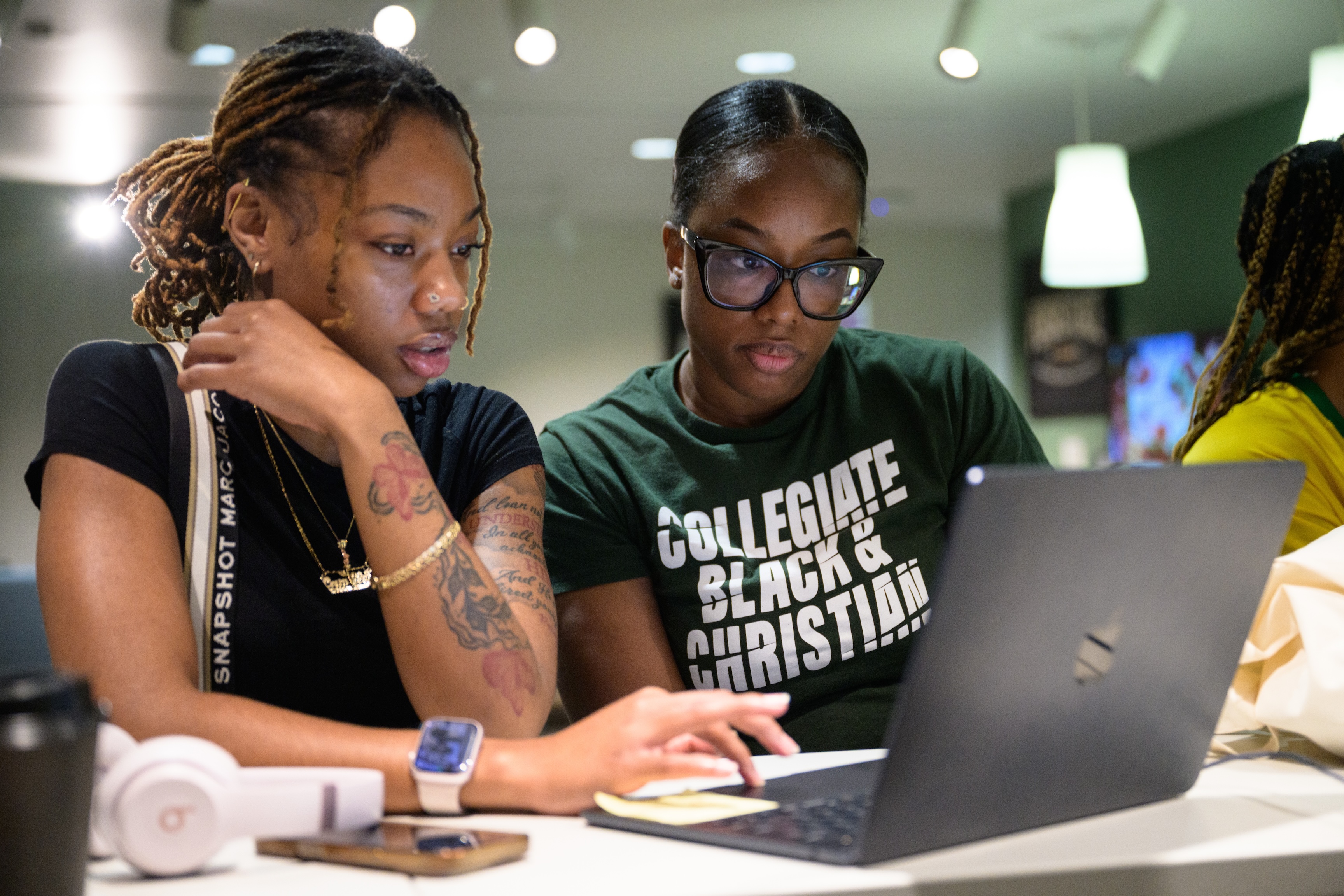 2 female BCM students looking at a laptop