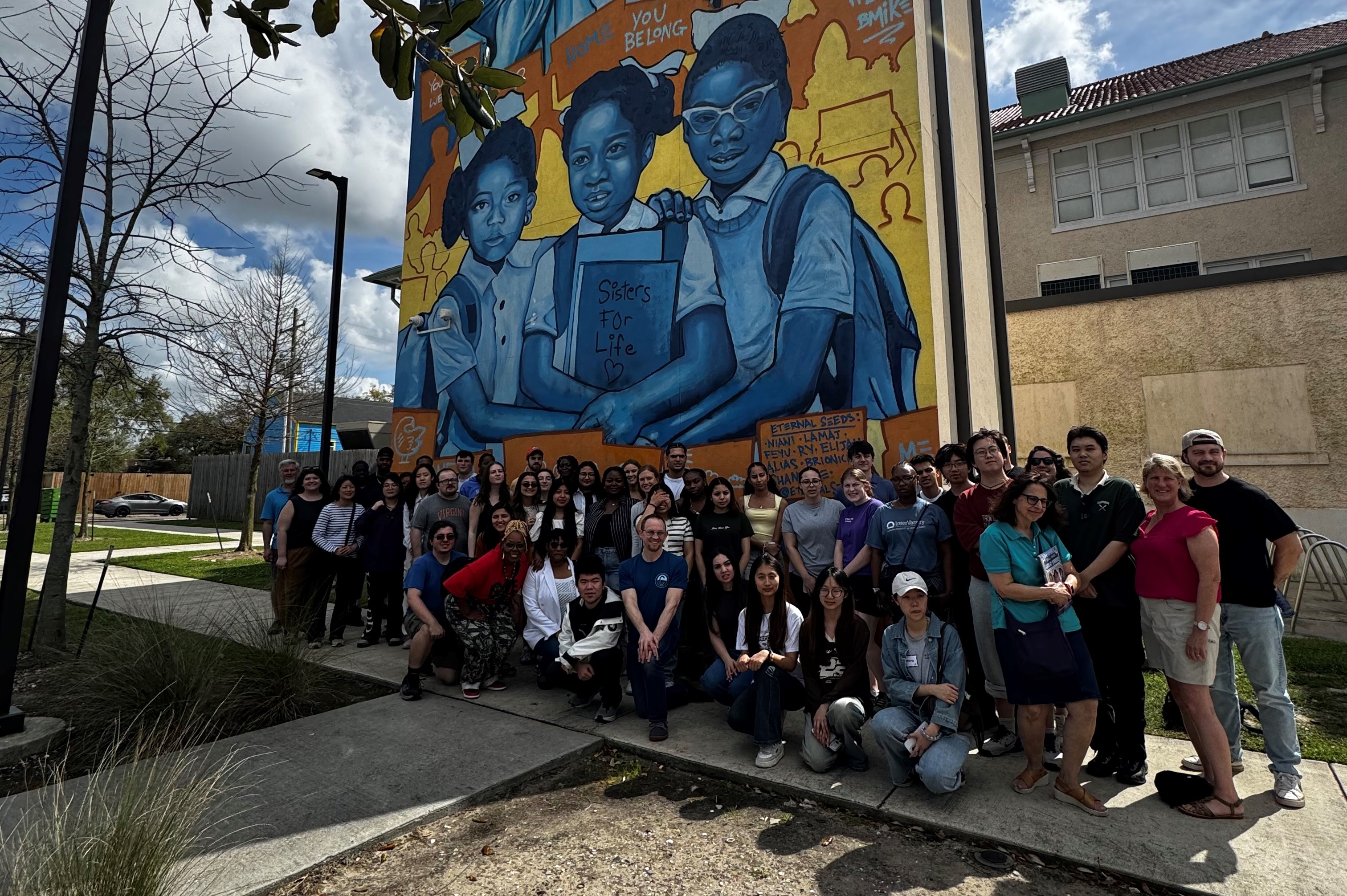 group photo in front of mural painting