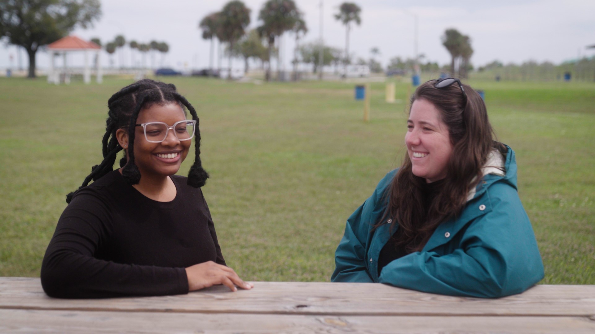 student and staff sit at picnic table