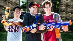 Three young male students posing with Nerf guns