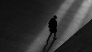 Black and white image of man walking alone