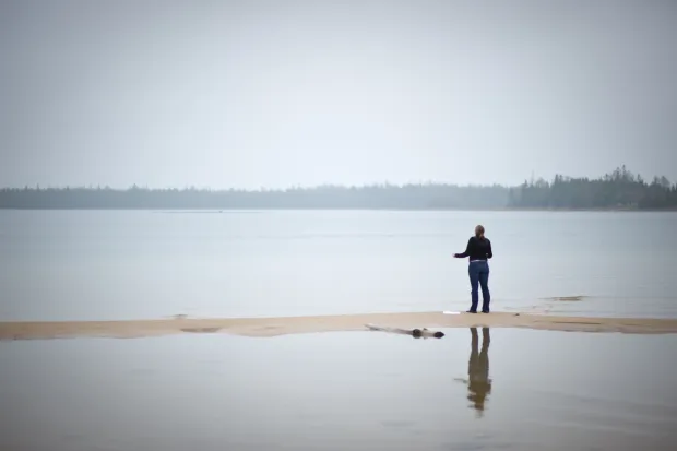 person standing alone on a lake