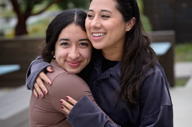 two women hugging on campus