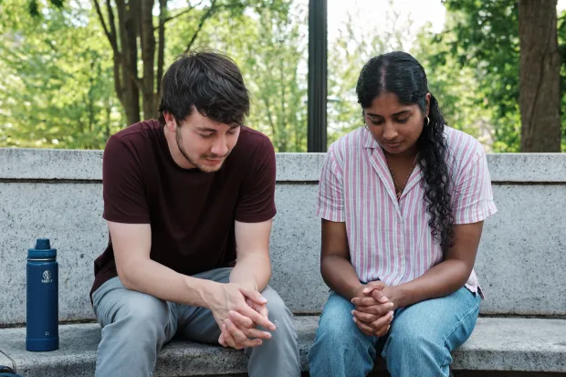 two staff praying outside