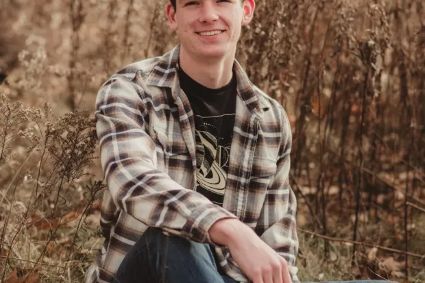 portrait of Austin sitting outside 
