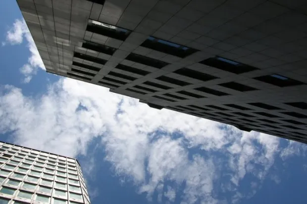 a blue sky with white clouds above two skyscrapers