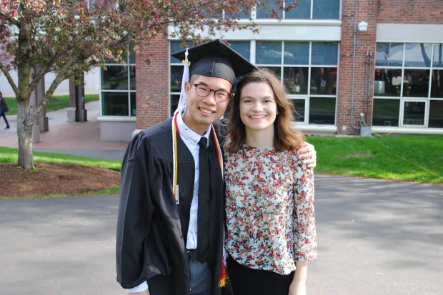 Taylor standing with friend Edwin in his graduation robe