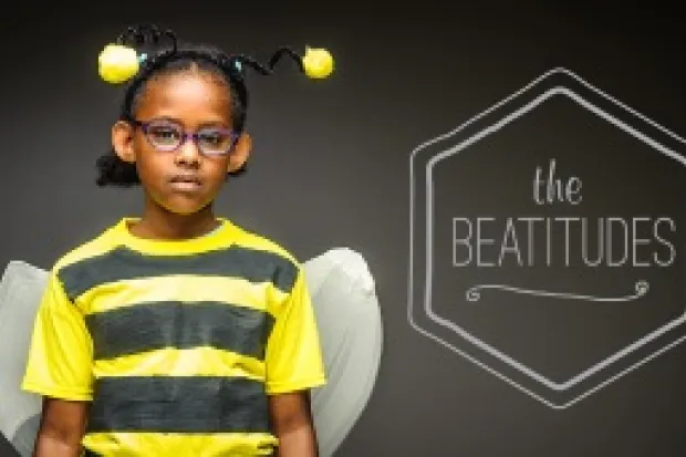 young girl in bee costume, dark gray background