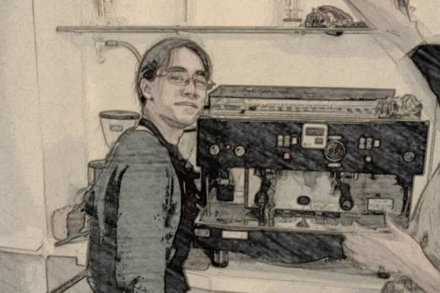 Sepia, edited photo of young man working as a barista with apron and glasses, standing in front of cappuccino machine