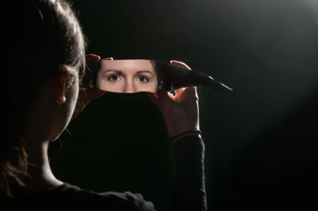 a woman's eyes reflected in a shard of glass