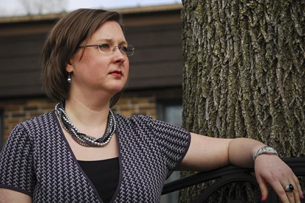 Woman sitting on bench outside looking thoughtful