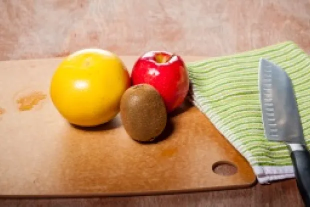 a wooden table with fruits, vegetables, and knife