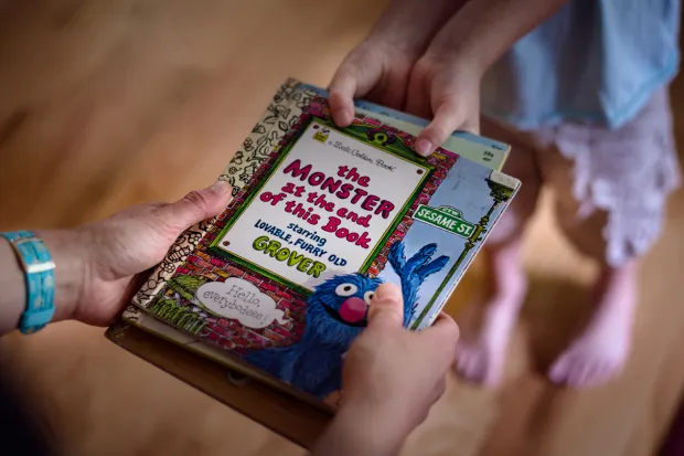 The hands of two children fighting over picture book