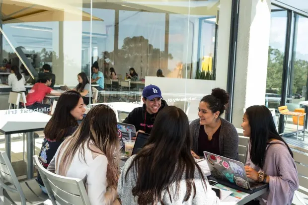 Group of students gathered outside laughing and discussing