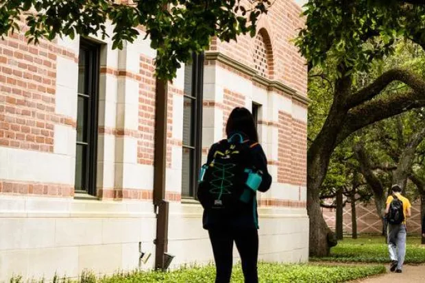 Several students walking down sidewalk on campus