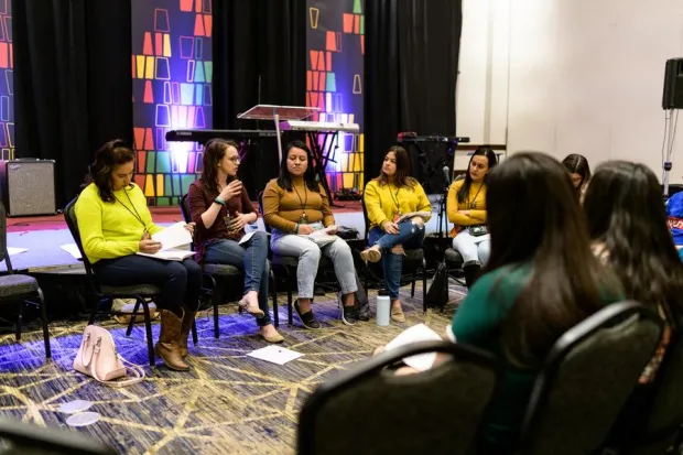 Group of Latino students seated in circle for conference