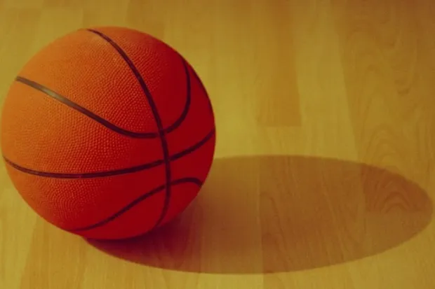 Orange basketball on indoor wooden court