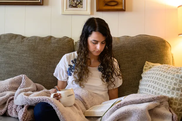 woman sitting on the couch and reading