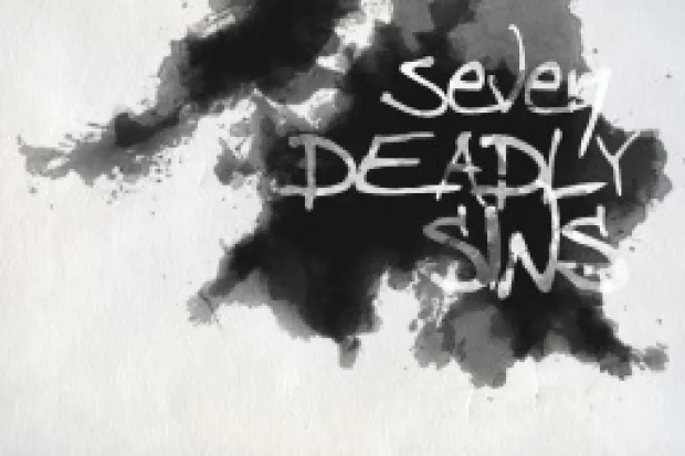 Ink blot on a white background with the words "Seven Deadly Sins" written on it.