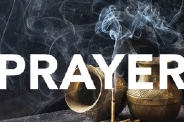 One urn turned on its side and one urn upright with stick of incense and the word "Prayer" across the image