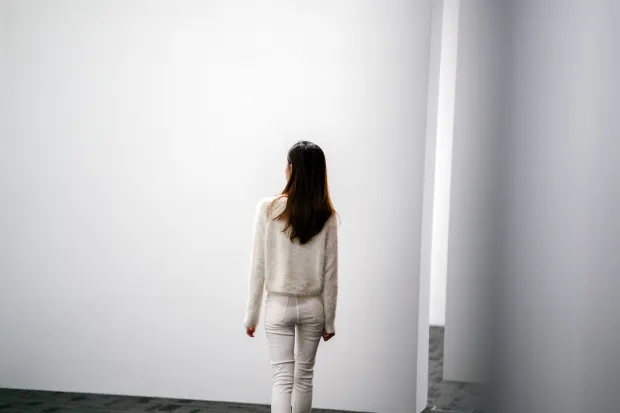 a woman examining a blank white wall