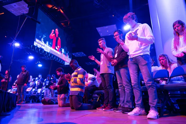 Group of students worshiping and praying at Urbana