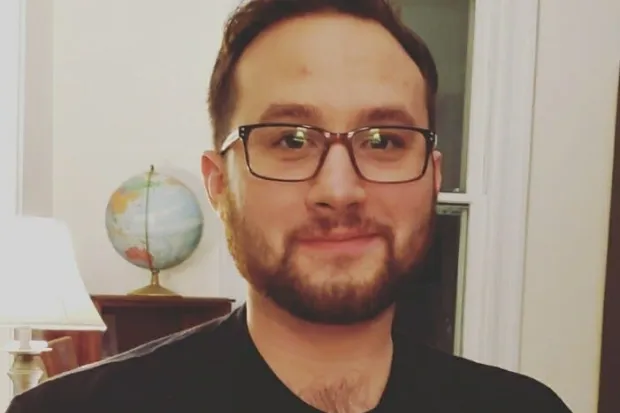 a man with a beard, brown hair, and glasses