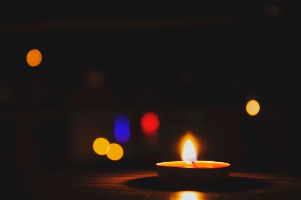 Closeup of candle with colorful lights in dark background