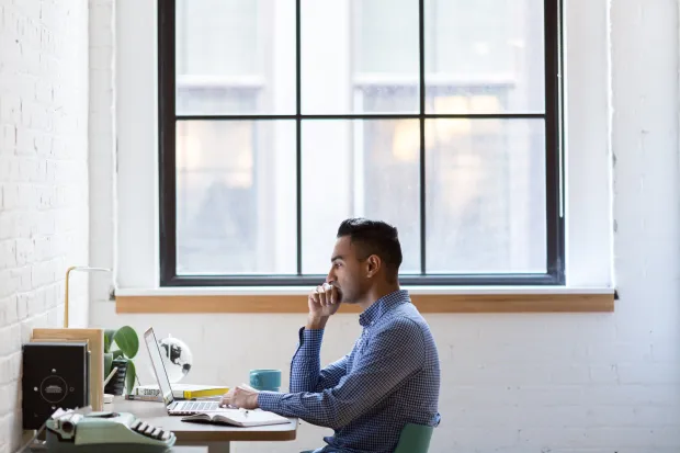 an adult businessman sitting at his desk and concentrating