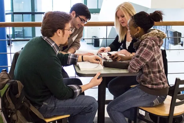 Group of diverse students gathered for Bible study in college student center