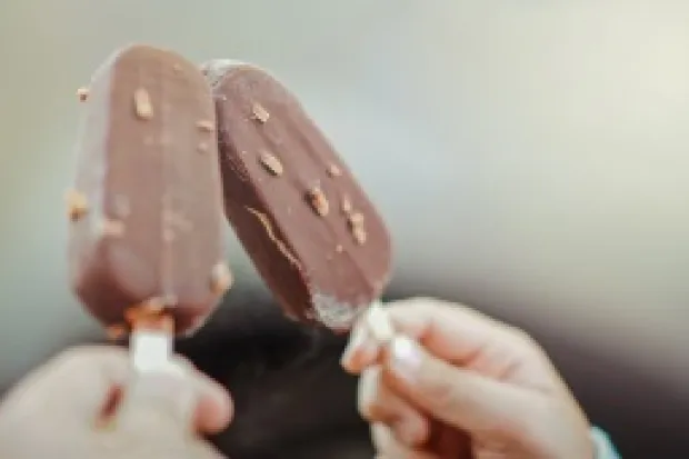 Two people holding up chocolate fudgesicles