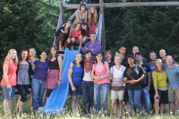 Large group of college students gathered around a playground slide