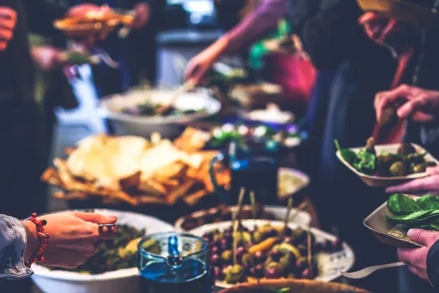 Closeup of large spread of food and people's plates