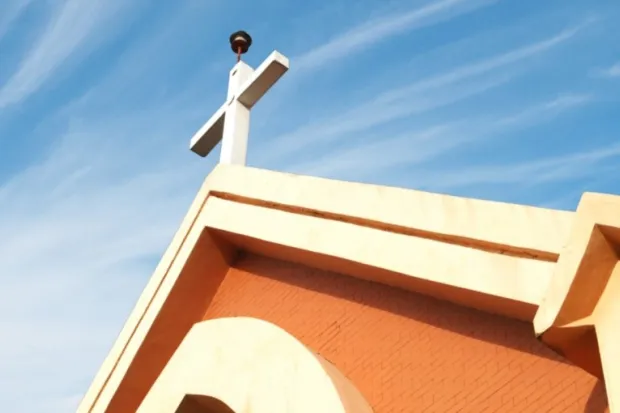 Closeup of church steeple rising up into blue sky