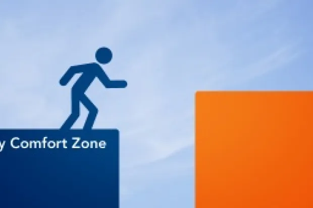 Stick person drawing on a blue block reading "comfort zone" preparing to leap to an orange block