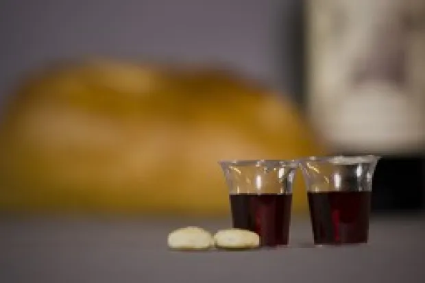 Two small communion cups and two pieces of bread