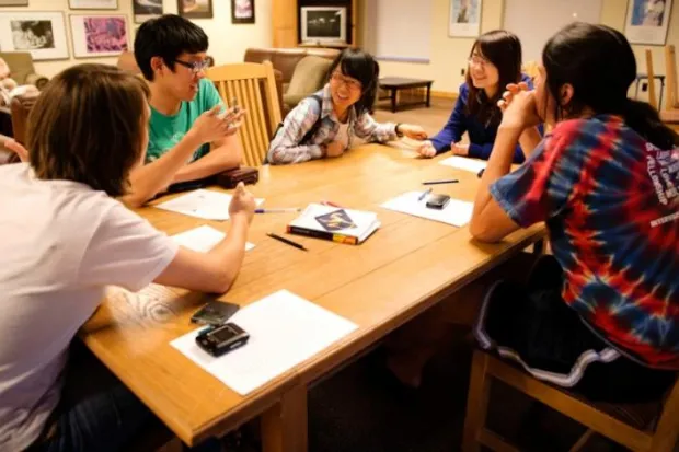 a group of students talking around a table