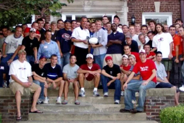 Group photo of male college students outside fraternity house