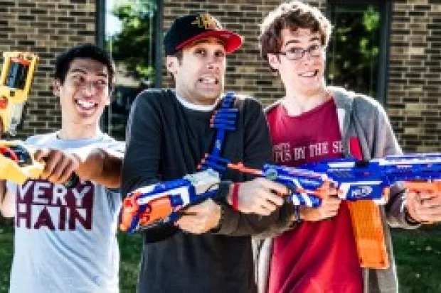 Three young male students posing with Nerf guns