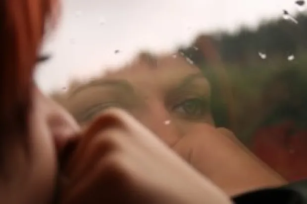 Closeup of woman looking out the window on a rainy day