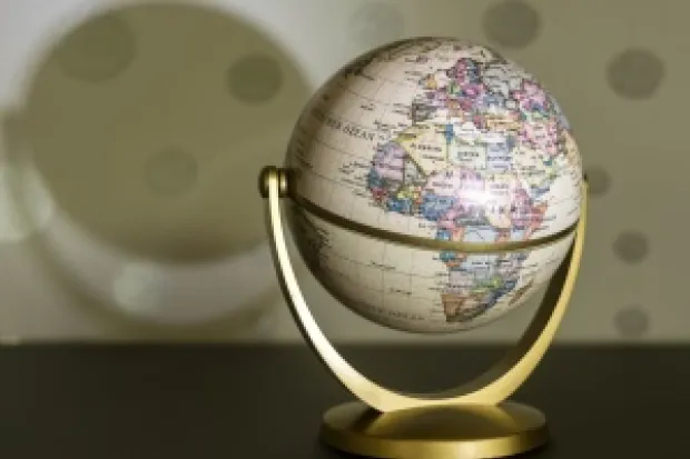 Globe sitting on counter with its shadow spreading across the wall